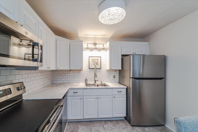 2601 Kenzie Ter Unit 519, Saint Anthony, MN 55418 - kitchen featuring appliances with stainless steel finishes, backsplash, white cabinetry, a chandelier, and a textured ceiling
