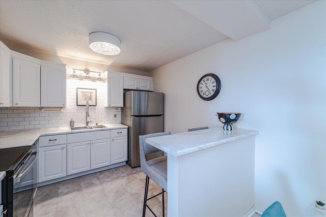 2601 Kenzie Ter Unit 519, Saint Anthony, MN 55418 - kitchen featuring appliances with stainless steel finishes, a breakfast bar area, white cabinetry, and light countertops