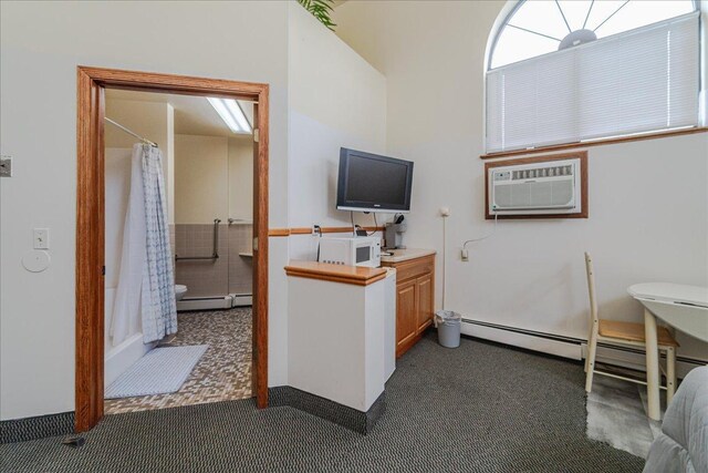 2601 Kenzie Ter Unit 519, Saint Anthony, MN 55418 - home office featuring a baseboard heating unit, a wall unit AC, and dark colored carpet