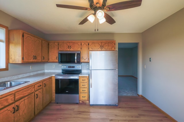 13752 Round Lake Blvd NW, Andover, MN 55304 - kitchen featuring stainless steel appliances, a ceiling fan, light wood-style flooring, and brown cabinetry