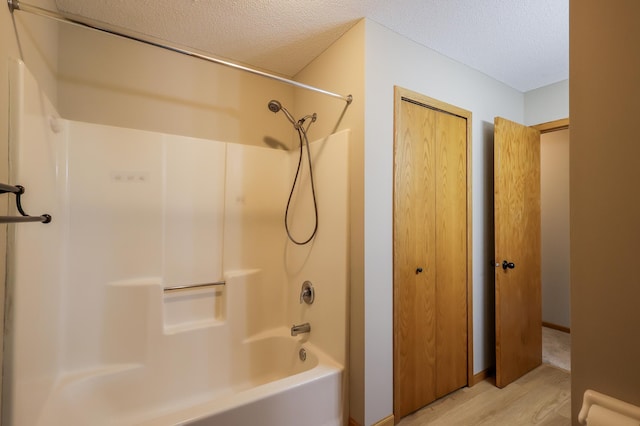 13752 Round Lake Blvd NW, Andover, MN 55304 - bathroom with a textured ceiling, bathtub / shower combination, and wood finished floors