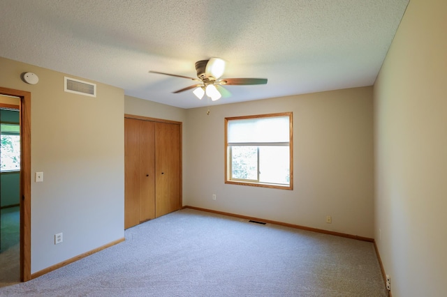 13752 Round Lake Blvd NW, Andover, MN 55304 - unfurnished bedroom featuring light carpet, a closet, a textured ceiling, and a ceiling fan