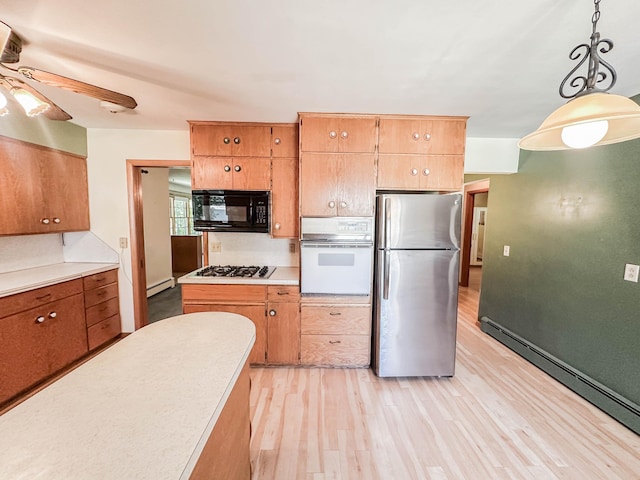 540 8th St, Bird Island, MN 55310 - kitchen featuring freestanding refrigerator, oven, black microwave, gas stovetop, and light wood finished floors