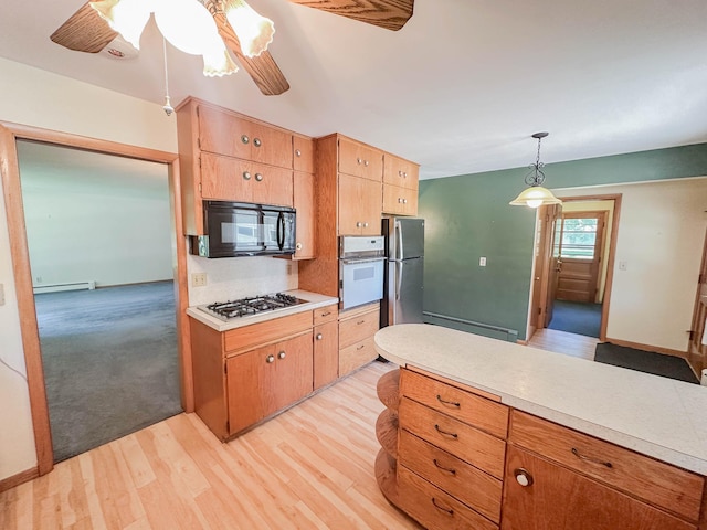 540 8th St, Bird Island, MN 55310 - kitchen with black microwave, white oven, freestanding refrigerator, gas cooktop, and light countertops