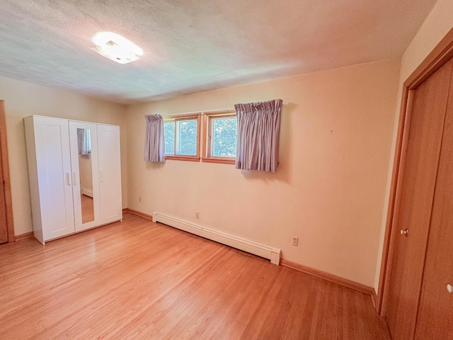 540 8th St, Bird Island, MN 55310 - unfurnished bedroom with a baseboard radiator and light wood-type flooring