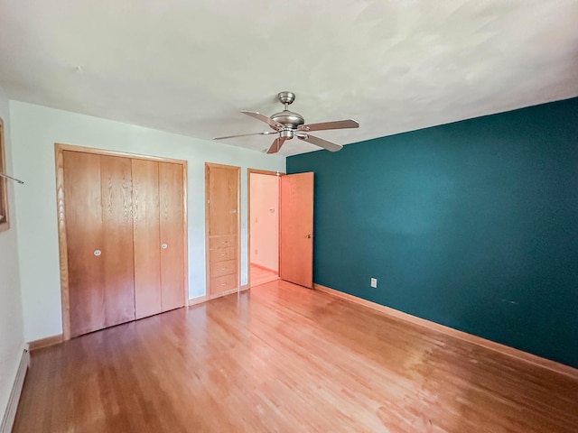 540 8th St, Bird Island, MN 55310 - unfurnished bedroom with wood finished floors, a ceiling fan, and a baseboard heating unit