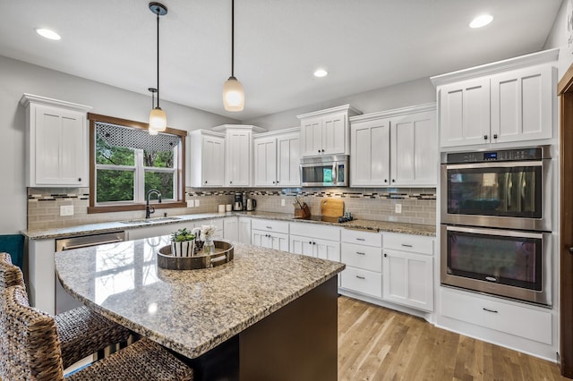 1799 158th Ln NW, Andover, MN 55304 - kitchen featuring stainless steel appliances, white cabinets, a kitchen bar, and recessed lighting