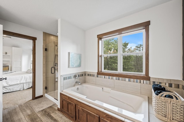 1799 158th Ln NW, Andover, MN 55304 - ensuite bathroom featuring a stall shower, a bath, and wood finished floors