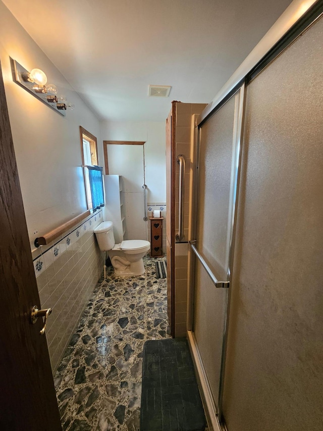 15596 464th St, Hewitt, MN 56453 - bathroom with stone finish flooring, a shower stall, and a wainscoted wall