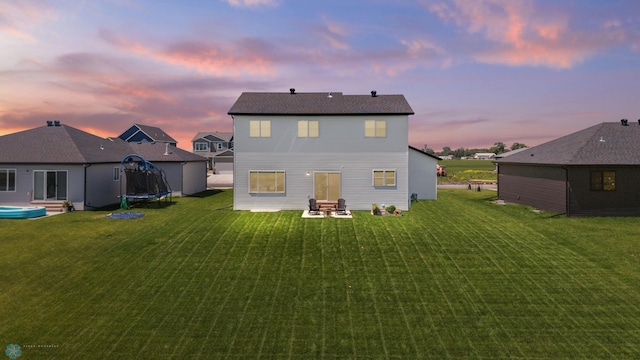 10128 Concord Dr, Horace, ND 58047 - back of property at dusk with a trampoline, a yard, and a patio
