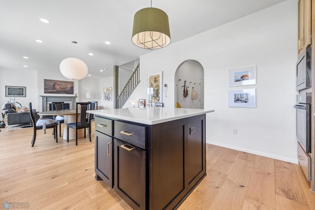 10128 Concord Dr, Horace, ND 58047 - kitchen with open floor plan, light wood-type flooring, a fireplace, light countertops, and recessed lighting