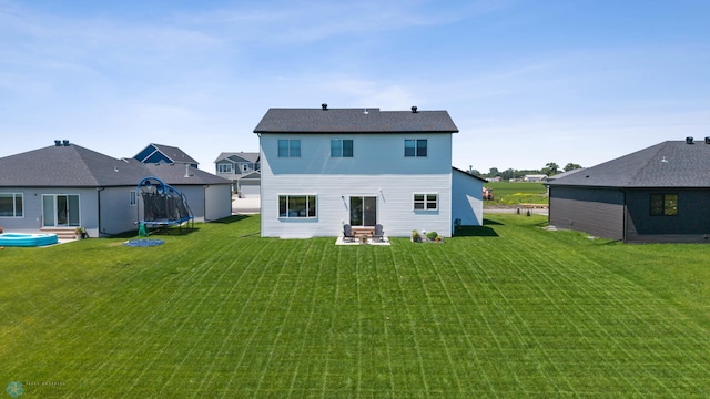 10128 Concord Dr, Horace, ND 58047 - back of house featuring a trampoline, a yard, and a patio