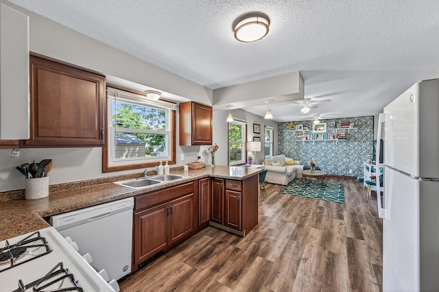 3850 Bryant Ave N, Minneapolis, MN 55412 - kitchen featuring white appliances, a textured ceiling, open floor plan, dark wood-style flooring, and a peninsula