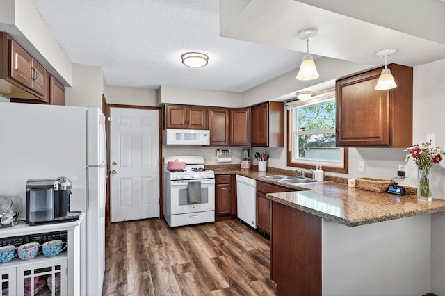 3850 Bryant Ave N, Minneapolis, MN 55412 - kitchen featuring white appliances, a peninsula, dark wood finished floors, hanging light fixtures, and brown cabinets