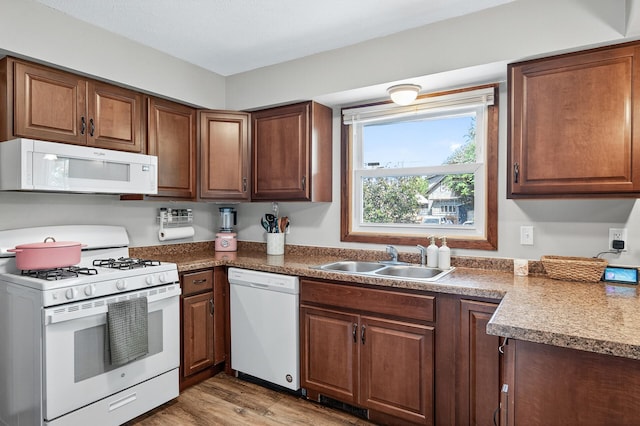 3850 Bryant Ave N, Minneapolis, MN 55412 - kitchen with white appliances, light wood-style floors, and brown cabinetry