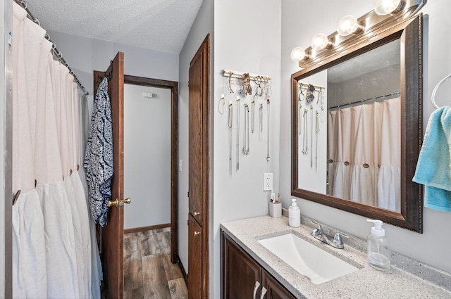 3850 Bryant Ave N, Minneapolis, MN 55412 - full bath with vanity, wood finished floors, and a textured ceiling