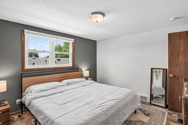 3850 Bryant Ave N, Minneapolis, MN 55412 - bedroom featuring a textured ceiling and wood finished floors