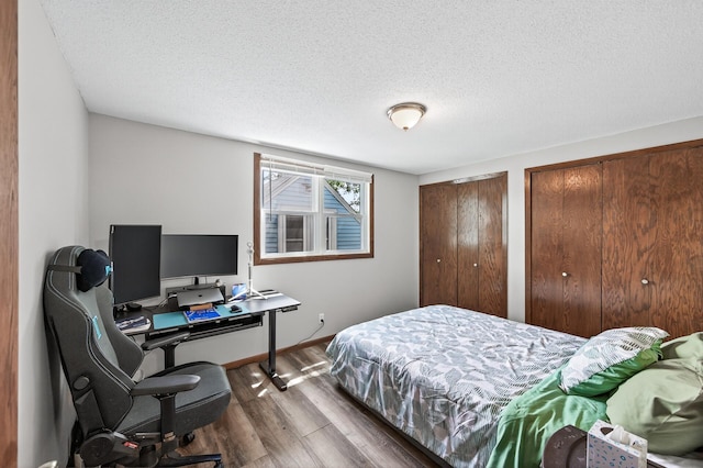 3850 Bryant Ave N, Minneapolis, MN 55412 - bedroom featuring wood finished floors, two closets, a textured ceiling, and a desk