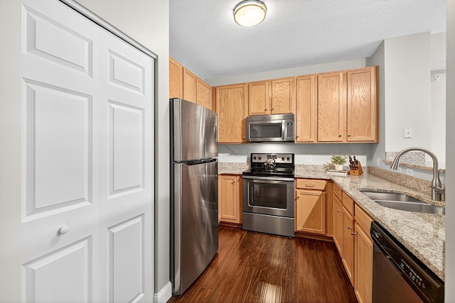 545 1st St Unit 400, Minneapolis, MN 55401 - kitchen featuring appliances with stainless steel finishes, dark wood-type flooring, light stone countertops, a textured ceiling, and light brown cabinetry