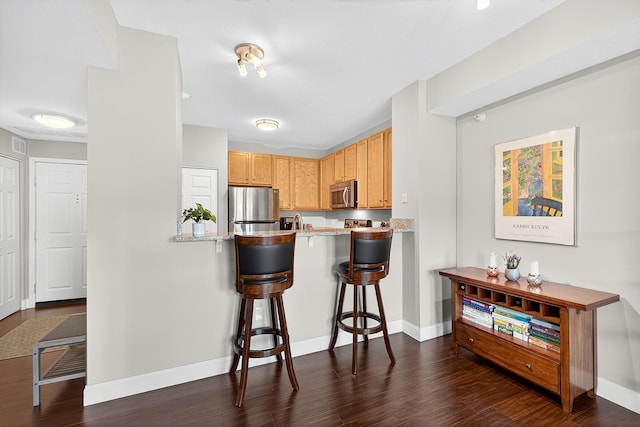 545 1st St Unit 400, Minneapolis, MN 55401 - kitchen with stainless steel appliances, a breakfast bar, dark wood finished floors, and a peninsula