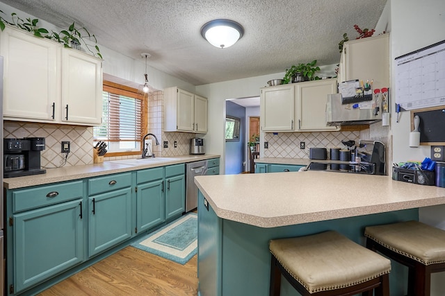 19161 Zane St NW, Elk River, MN 55330 - kitchen featuring a breakfast bar, light wood-style floors, a textured ceiling, plenty of natural light, and stainless steel dishwasher