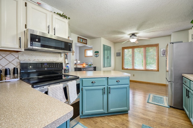 19161 Zane St NW, Elk River, MN 55330 - kitchen featuring stainless steel appliances, a peninsula, light countertops, tasteful backsplash, and a textured ceiling