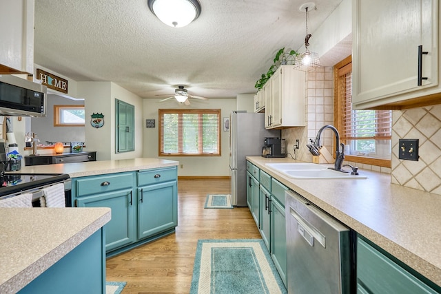 19161 Zane St NW, Elk River, MN 55330 - kitchen with appliances with stainless steel finishes, light countertops, light wood finished floors, decorative backsplash, and ceiling fan