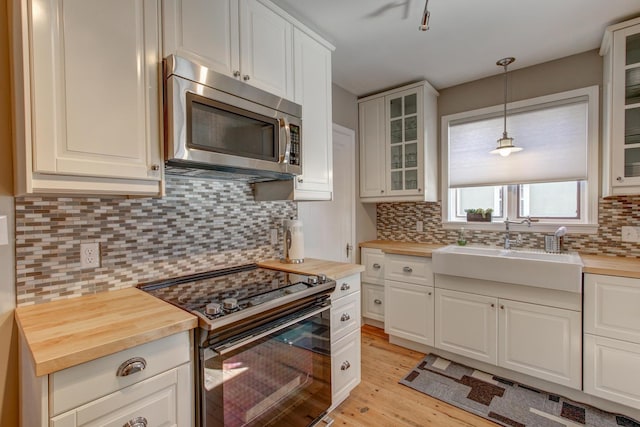 1331 2nd St NW, Rochester, MN 55901 - kitchen featuring stainless steel microwave, black electric range, butcher block counters, light wood-style floors, and tasteful backsplash
