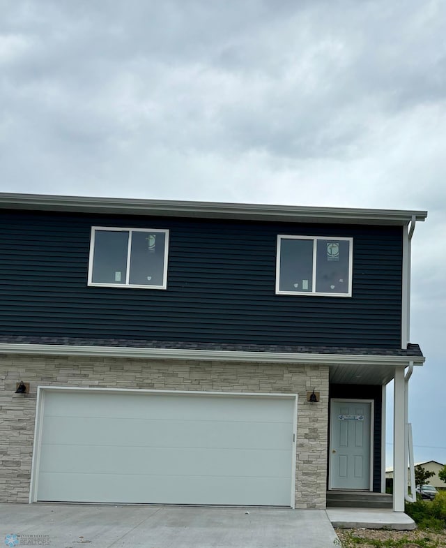 129 Pine Ave, Mapleton, ND 58059 - view of front of property featuring an attached garage and stone siding