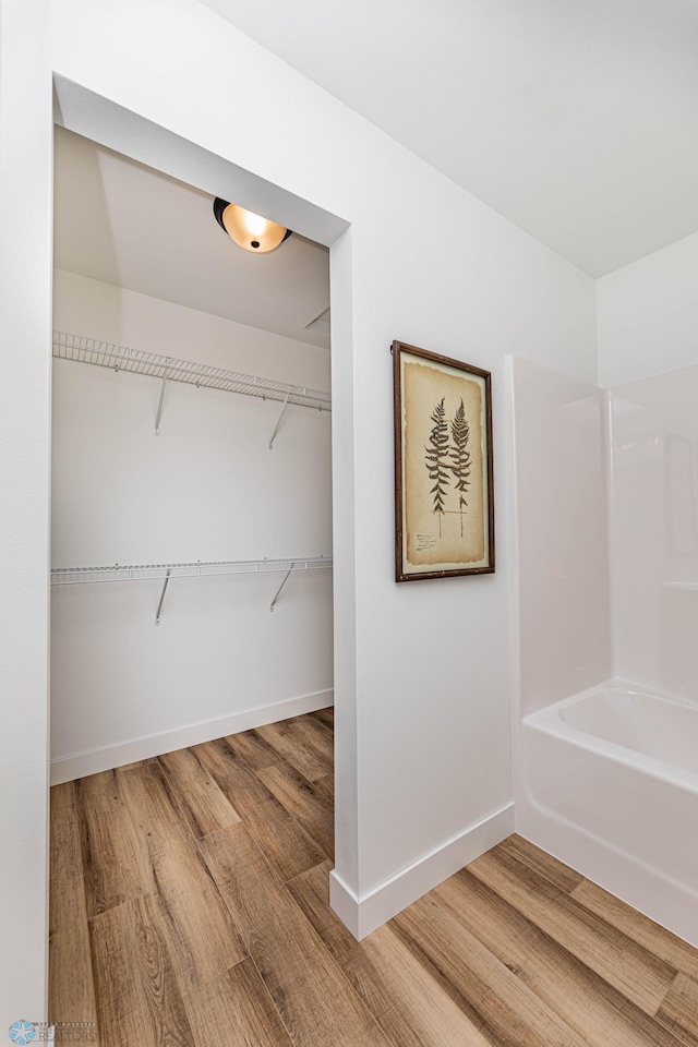 129 Pine Ave, Mapleton, ND 58059 - bathroom with wood finished floors and washtub / shower combination