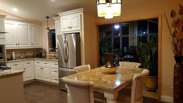 2108 74th Ave N, Brooklyn Park, MN 55444 - kitchen with appliances with stainless steel finishes, dark wood-type flooring, light stone countertops, white cabinetry, and vaulted ceiling
