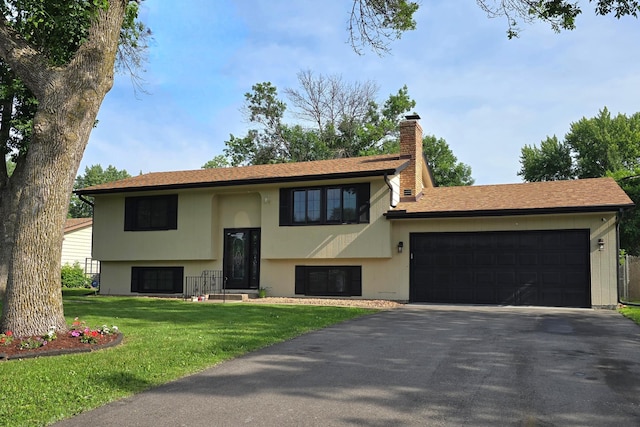 2108 74th Ave N, Brooklyn Park, MN 55444 - split foyer home with driveway, a garage, a front lawn, a chimney, and stucco siding