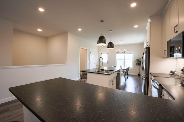 1267 Naser Way, New Richmond, WI 54017 - kitchen with appliances with stainless steel finishes, a center island with sink, dark wood-style flooring, recessed lighting, and a chandelier