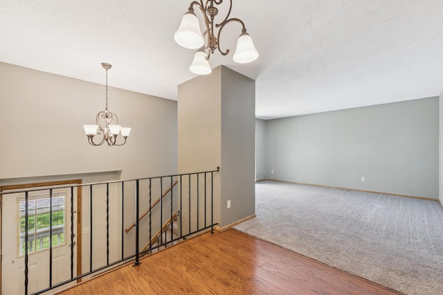 510 78th Ave NE, Spring Lake Park, MN 55432 - empty room featuring a chandelier, wood finished floors, carpet floors, and a textured ceiling