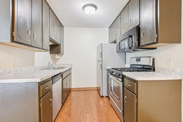 510 78th Ave NE, Spring Lake Park, MN 55432 - kitchen with stainless steel appliances, light wood-type flooring, a textured ceiling, and light countertops