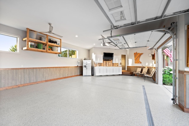 1899 White Oak Dr, Chaska, MN 55318 - garage with white fridge with ice dispenser, wainscoting, a garage door opener, and wood walls