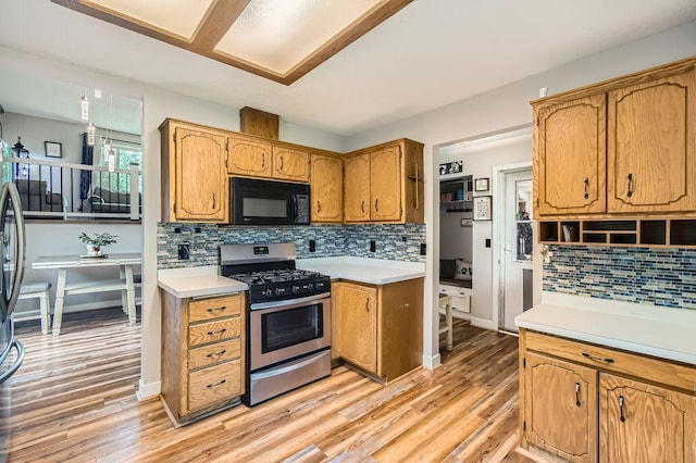 7236 Clear Rdg, Centerville, MN 55038 - kitchen with black microwave, gas range, light countertops, backsplash, and light wood-type flooring