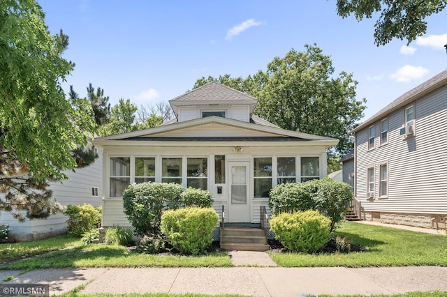 727 Virginia St, Saint Paul, MN 55103 - view of front facade with a shingled roof, a front lawn, cooling unit, and a sunroom