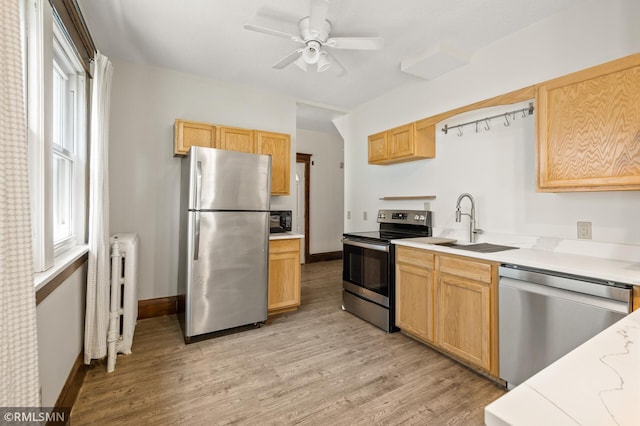 727 Virginia St, Saint Paul, MN 55103 - kitchen with stainless steel appliances, light countertops, light wood-style flooring, and ceiling fan