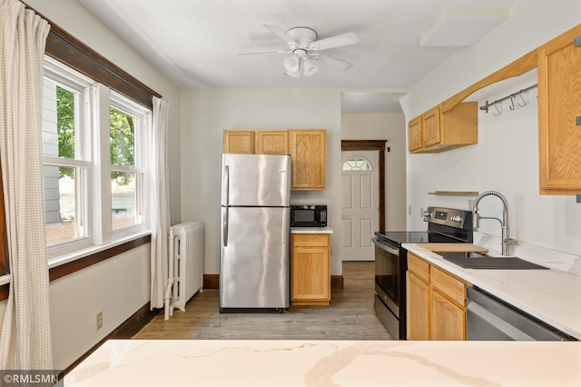 727 Virginia St, Saint Paul, MN 55103 - kitchen with appliances with stainless steel finishes, radiator, light wood-type flooring, light stone counters, and ceiling fan