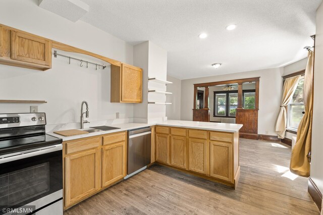727 Virginia St, Saint Paul, MN 55103 - kitchen featuring stainless steel appliances, a peninsula, light countertops, light wood-style flooring, and recessed lighting