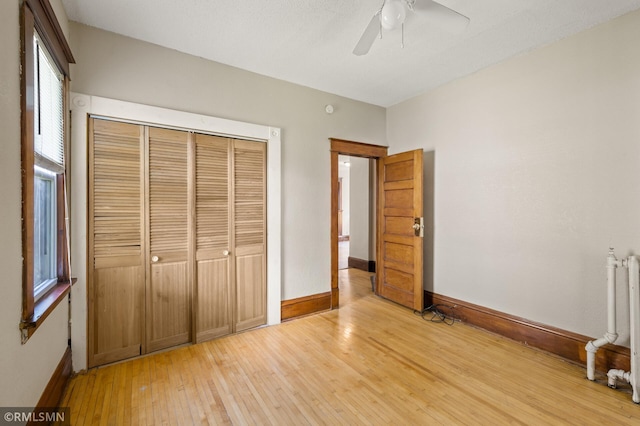 727 Virginia St, Saint Paul, MN 55103 - unfurnished bedroom featuring light wood-style flooring, a closet, a ceiling fan, and radiator