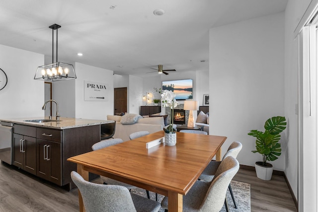 12910 Brenly Way, Rogers, MN 55374 - dining space with wood finished floors, ceiling fan, a chandelier, a glass covered fireplace, and recessed lighting