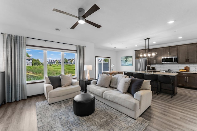 12910 Brenly Way, Rogers, MN 55374 - living room with light wood-style flooring, a ceiling fan, a chandelier, and recessed lighting