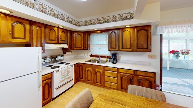 1314 Dunham St, Albert Lea, MN 56007 - kitchen featuring white appliances, under cabinet range hood, light countertops, and brown cabinetry