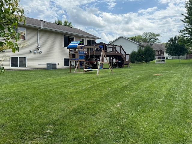1070 20th St NE, Owatonna, MN 55060 - rear view of house featuring a yard, a deck, a shingled roof, and a playground