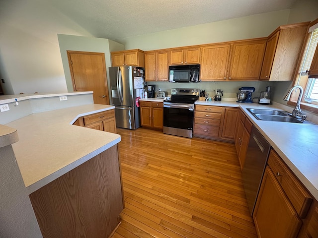 1070 20th St NE, Owatonna, MN 55060 - kitchen with appliances with stainless steel finishes, brown cabinets, light countertops, and light wood-type flooring