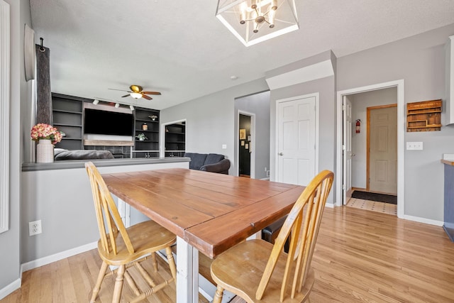 2418 Thrush St, Shakopee, MN 55379 - dining area with light wood finished floors, a textured ceiling, a ceiling fan, and a chandelier