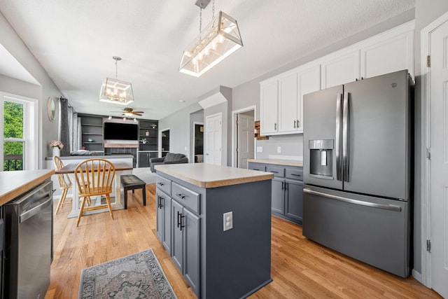 2418 Thrush St, Shakopee, MN 55379 - kitchen featuring stainless steel appliances, light countertops, ceiling fan, white cabinetry, and light wood-type flooring