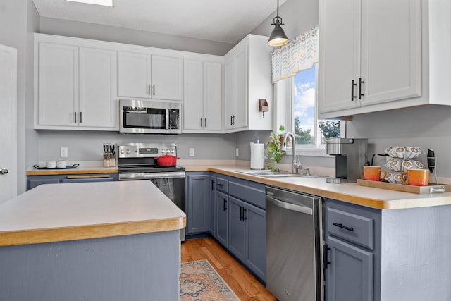 2418 Thrush St, Shakopee, MN 55379 - kitchen with stainless steel appliances, light countertops, pendant lighting, and white cabinetry